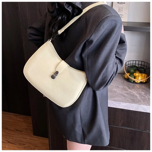 Detail view of cream white faux leather shoulder bag with silver metal swivel lock clasp