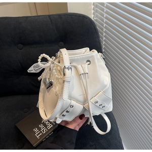 Vue détaillée du sac seau blanc avec breloques en perles et nœud en dentelle élégant