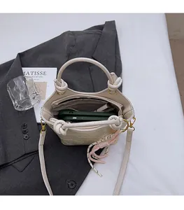 Interior view of white embossed bucket bag showing dual compartments for phone and makeup