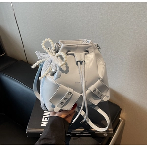Détail du sac seau plissé gris clair avec nœud en perles et dentelle blanche