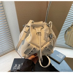 Détails du sac seau en cuir beige avec perles, dentelle et breloque en forme de cœur