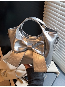 Silberne Metallic-Beuteltasche mit großer Schleife und Kettenriemen im modernen Stil