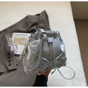 Sac seau bleu glacé avec charm nœud en dentelle et perles et fermeture par cordon