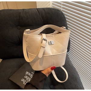 Dettaglio borsa a secchiello trapuntata beige con chiusura a scatto in argento