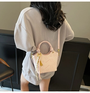 Pink cartoon handbag featuring embossed animal patterns and a yellow silk scarf charm
