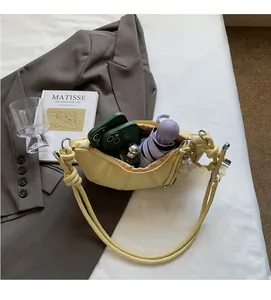 Spacious interior of yellow crescent bag with phone, umbrella and accessories