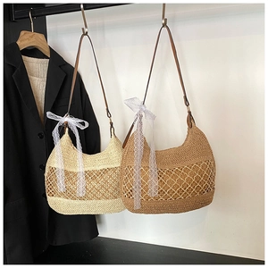 Detail of hand-woven straw shoulder bags in beige and caramel with lace bow accents
