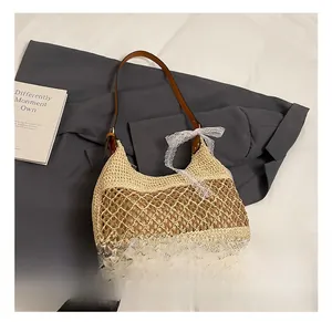Detail of straw woven bag with white lace bow and brown leather shoulder strap