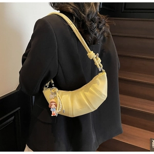 Adjustable knotted shoulder strap and textured leather detail of the yellow crescent bag