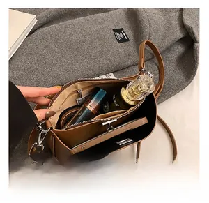 Interior view of brown leather crossbody bag showing space for phone and cosmetics