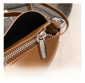 Detail of premium brown pebble leather texture with branded KOSK silver zipper hardware