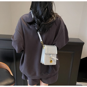 Silver-grey metallic crossbody phone bag detail showing size and strap fit on model