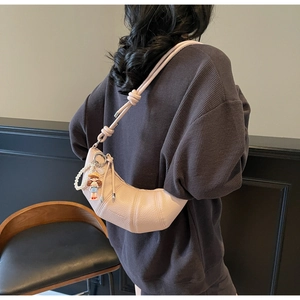 Pink crescent horn bag with knotted strap and pearl charms shown on female model