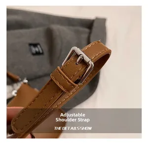 Macro detail of brown leather shoulder strap with adjustable silver metal buckle