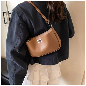 Detailed back view of a woman wearing the brown PU leather underarm bag with silver buckle