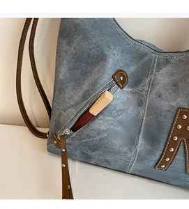Detail of blue denim tote bag side zipper pocket showing storage for lipstick