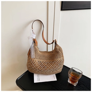 Detail of woven straw shoulder bag featuring intricate lace ribbon and leather strap