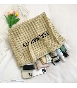 Spacious interior of a beige straw tote bag showing capacity for phone and umbrella