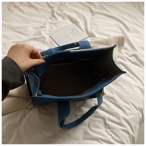 Vue détaillée de l'intérieur du sac en jean avec compartiments et poche zippée