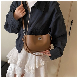 Close-up of the brown leather shoulder bag featuring a silver metal twist lock closure