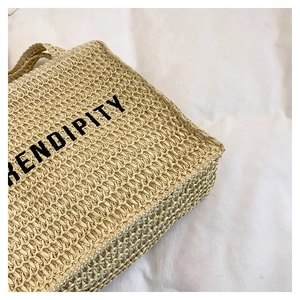 Close-up of beach straw tote bag featuring detailed weaving and Serendipity lettering