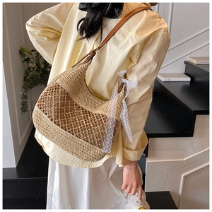 Detail of straw woven tote bag featuring hollow mesh pattern and white lace bow decoration