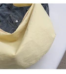 Nahaufnahme der weichen gelben Nylon-Tragetasche mit Reißverschluss auf blauem Denim
