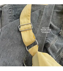 Detail des verstellbaren Schultergurts mit silberner Metallschnalle an gelber Tasche