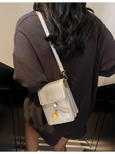 Chic silver vertical crossbody phone bag with gold metal pendant and textured finish
