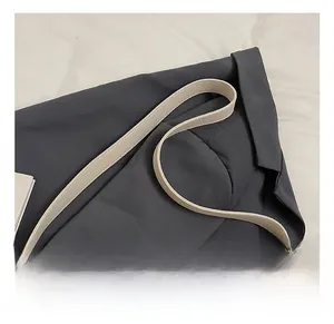 Detail of the soft lychee grain leather strap on a beige retro bucket shoulder bag