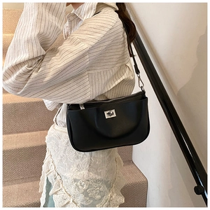 Detail view of the elegant black shoulder bag with its silver metallic twist lock closure