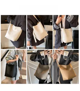 Detail view of large bucket bag in white, black, grey and brown colors on models