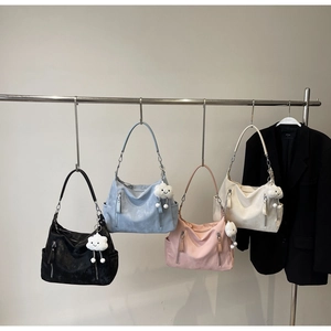 Détail de quatre sacs fourre-tout minimalistes colorés avec des breloques nuage pelucheuses