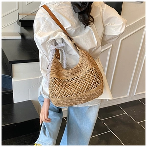 Detailed close-up of straw hobo bag showing woven texture and white lace detail