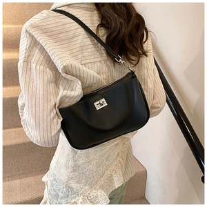 Chic black leather underarm bag with silver twist lock shown on model's shoulder