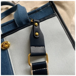 Détail du patchwork en denim et toile avec bordure en cuir bleu et finitions dorées