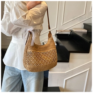 Detail of hand-woven straw bag with hollow mesh design and elegant white lace bow