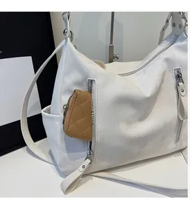Détail du grand sac cabas blanc avec multiples fermetures éclair et poches pratiques