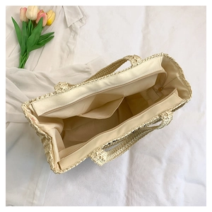 Close-up of woven straw tote bag featuring smooth zipper closure and inner pocket