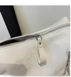 Détail de la fermeture éclair argentée et texture grainée sur le grand sac cabas