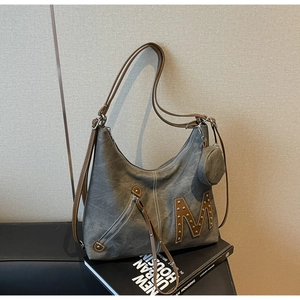 Detailed macro of washed canvas tote with brown leather trim and M letter applique
