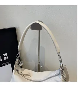 Détail du sac hobo blanc avec chaîne argentée et poignée en cuir sur support métal