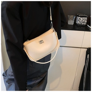 Chic cream underarm bag with silver twist-lock and dual shoulder straps worn by model