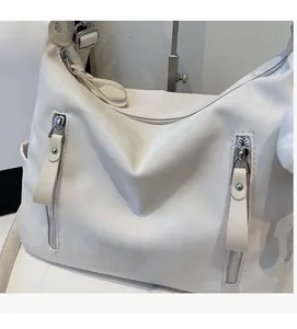 Détail du cuir synthétique blanc de qualité et de la fermeture éclair métallique du sac