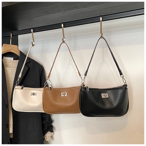Detailed display of underarm bags in beige, brown, and black with silver metal locks