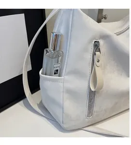 Détail du cabas blanc montrant une poche latérale pratique avec fermeture éclair verticale