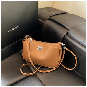 Detail view of the brown leather shoulder bag featuring a silver metal twist lock closure