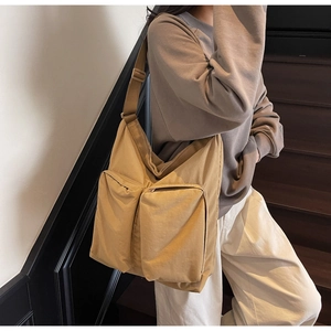 Lifestyle shot of large khaki canvas tote bag with front zip pockets and wide strap