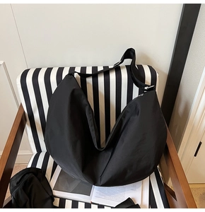Detail einer großen schwarzen Hobo-Tasche aus wasserfestem Nylon in minimalistischem Design