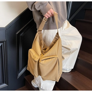 Detail of khaki utility tote bag featuring large functional front cargo pockets
